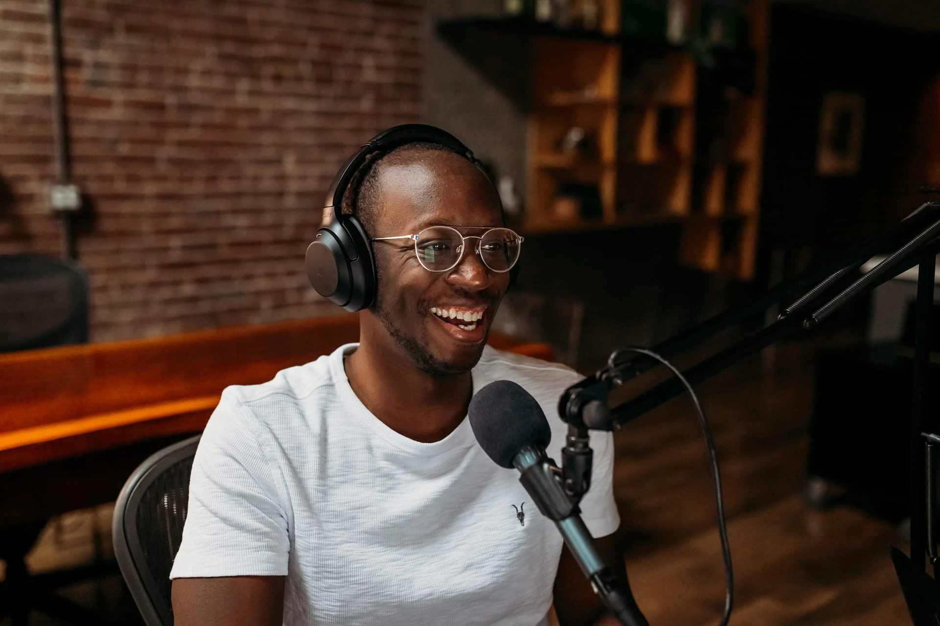 Creator recording a podcast episode in a studio with headphones and a microphone